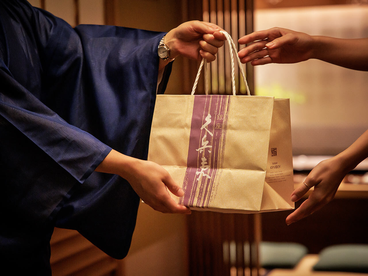 新橋『久兵衛 本店』の「バラちらし」を受け取っている様子