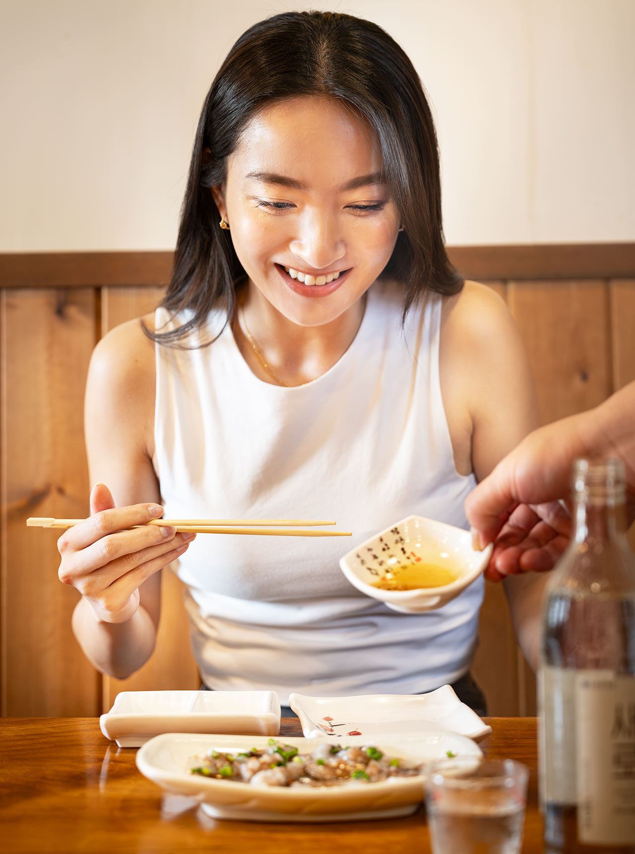 東新宿『海雲台 歌舞伎町店』で「生タコ」にゴマ油をかけている様子