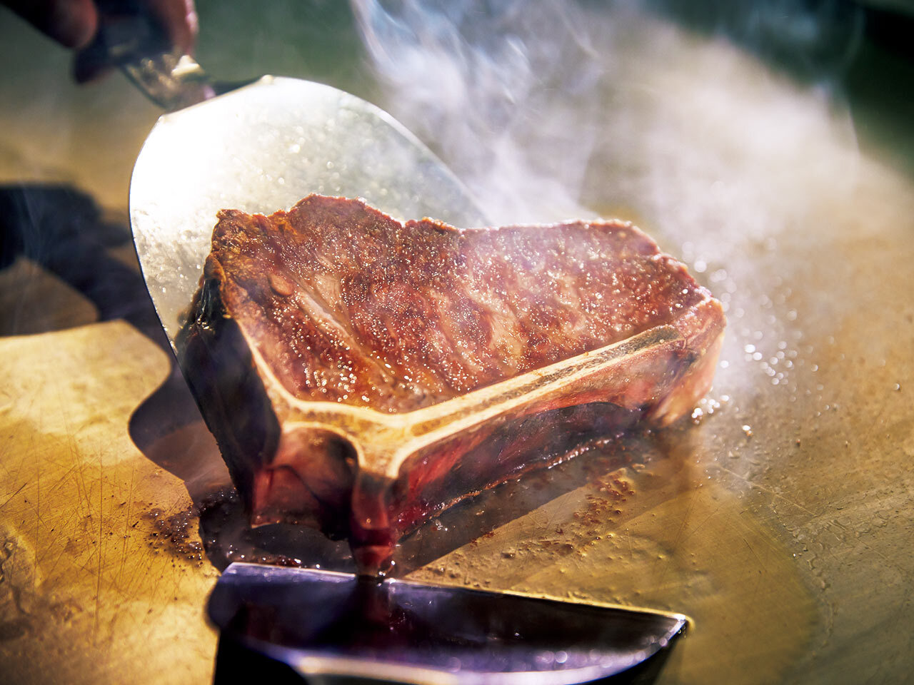 銀座一丁目『ウルフギャング・ステーキハウス TEPPAN』の骨付き肉を焼いている様子