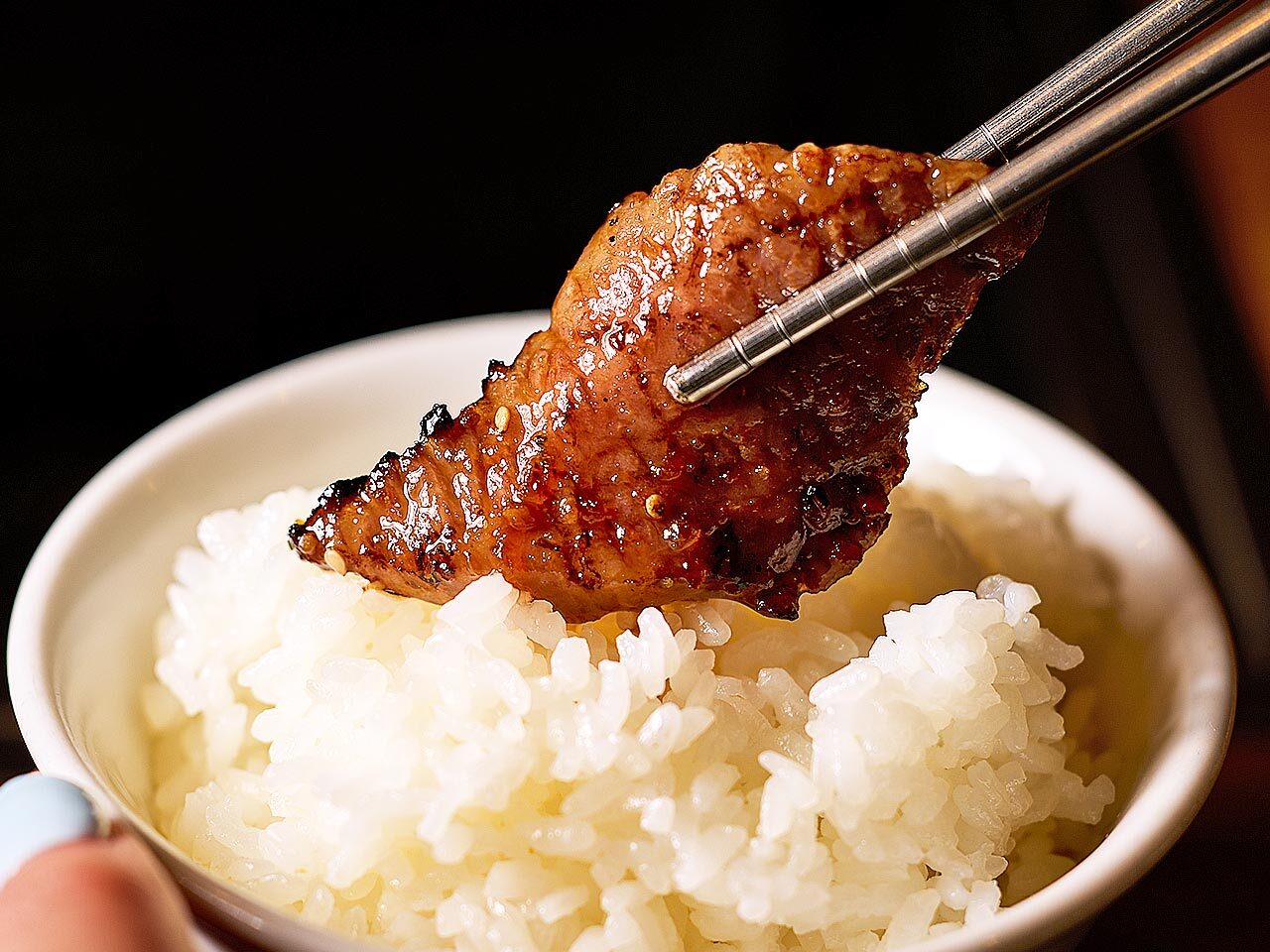 虎ノ門『虎ノ門 肉と日本酒』のタレ肉でご飯を巻いている様子